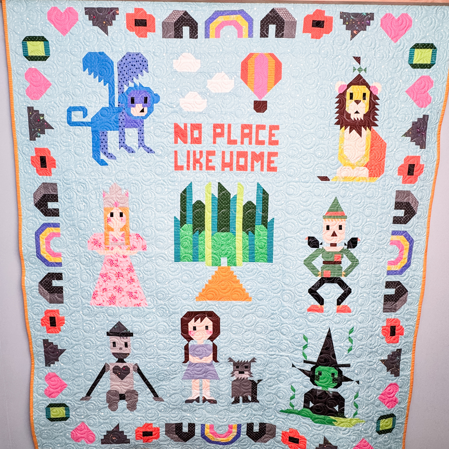 Complete Sew Place Like Home Wizard of Oz quilt hanging on the wall.