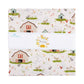 A folded fabric bundle wrapped with a white paper band. The fabric has a white background with a repeating farm-themed print featuring red and green barns, cows, sheep, chickens, and small flowers.