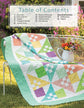 Quilt with colorful geometric pattern on a grassy outdoor setting