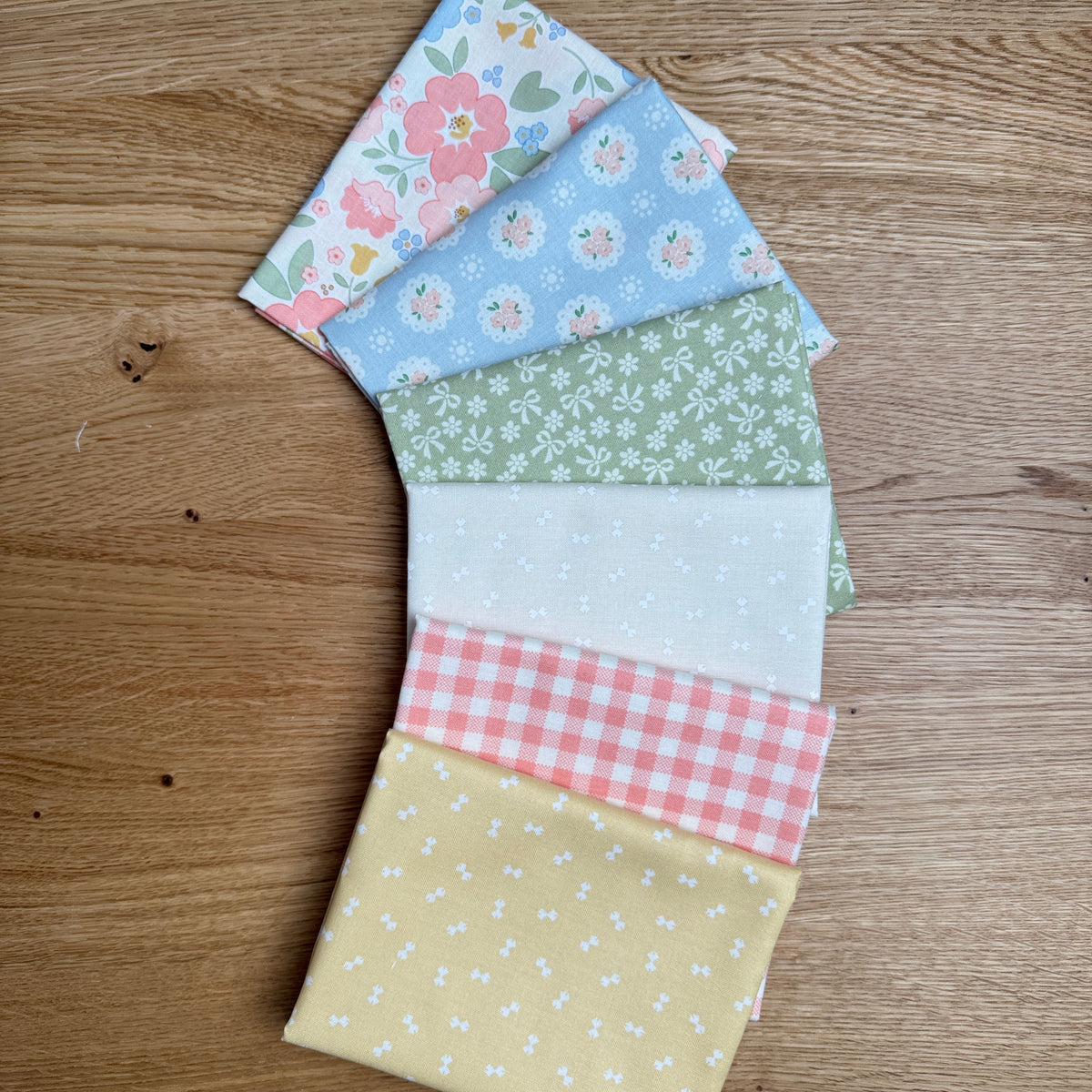Six coordinating fat quarter prints from the Handmade Sweetness Butterscotch bundle by My Sew Quilty Life for Moda Fabrics, fanned out to show the fabric designs.