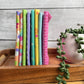 Joysome Cantaloupe 8-piece fat quarter bundle in orange tones, displayed standing on edge on a decorative tray beside a faux plant.