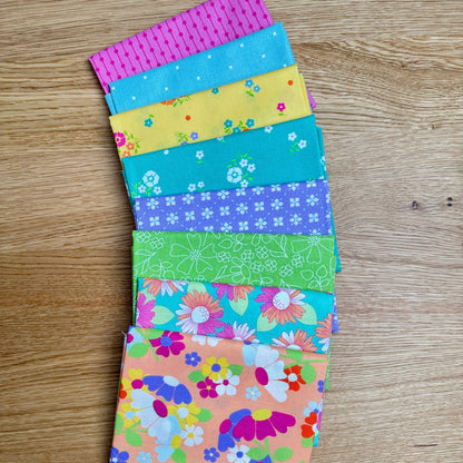 Joysome Cantaloupe Petite Fat Quarter Bundle by Corey Yoder for Moda Fabrics, featuring 8 curated orange prints fanned out to show the fabric designs.