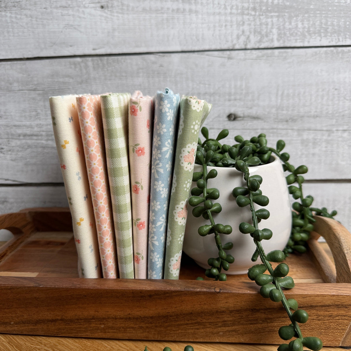 Handmade Sweetness Multi petite fat quarter bundle by My Sew Quilty Life for Moda Fabrics, featuring six coordinating prints displayed on a tray beside a decorative plant.