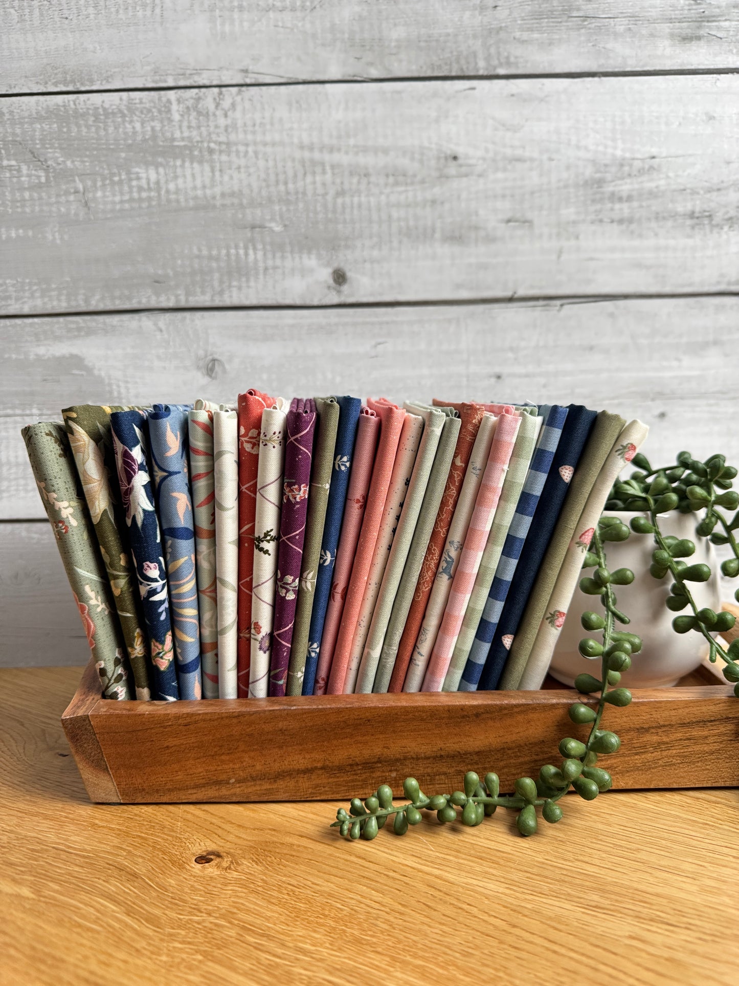 Flat lay of the Hedgerow Haven 24-piece fat quarter bundle by Amber Elliot of Alderwood Studio for Riley Blake Designs