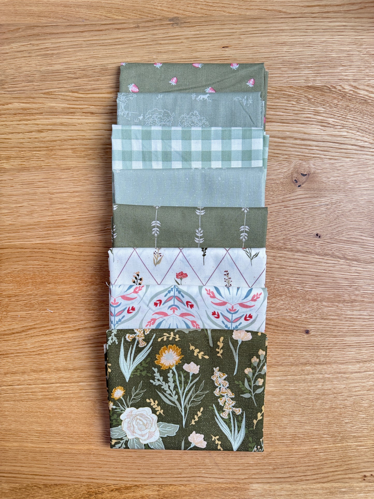 Flat lay of the Green Hedgerow Haven petite fat quarter bundle, 8 fat quarters by Amber Elliot of Alderwood Studio for Riley Blake Designs