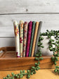 Cream Where the Wild Flowers Are petite fat quarter bundle standing on end on a wooden tray next to a plant
