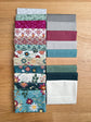 Flat lay of the Where the Wild Flowers Are 21-piece fat quarter bundle by Judi Madsen for Riley Blake Designs