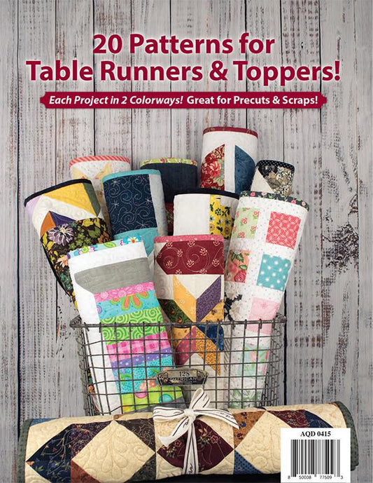 Tabletastic! back cover.  A quilted table runner and topper bundle displayed in a wire basket against a rustic whitewashed wood background. Large red text at the top reads '20 Patterns for Table Runners & Toppers!' with smaller supporting text about colorways and precuts/scraps.