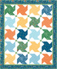 A square quilt or fabric panel design with a border and a grid of colorful pinwheel blocks. The center contains alternating pinwheel shapes in green, orange, yellow, light blue, and dark blue patterned fabrics on a white background.
