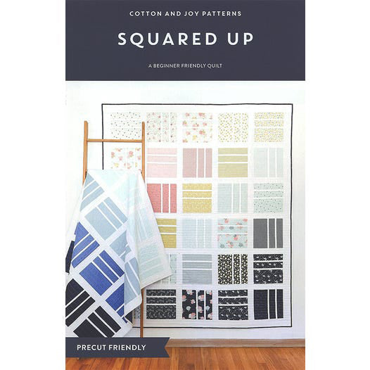 Squared Up quilt pattern cover by Cotton and Joy featuring a modern patchwork quilt made with 10-inch squares in a bold geometric layout.
