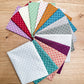 Fourteen Quiltessential Minis dot fat quarters by Laundry Basket Quilts, fanned out to show the fabrics.