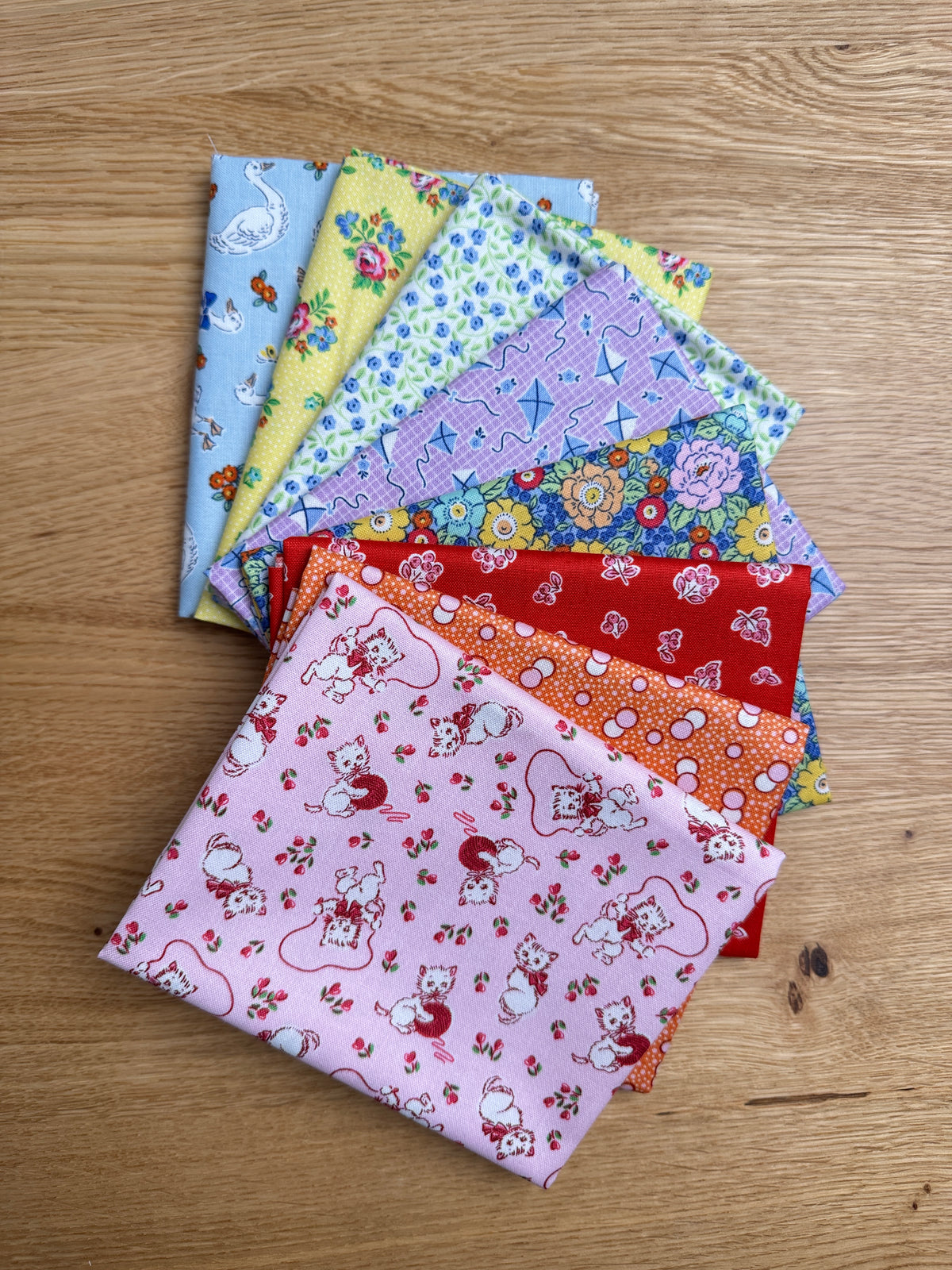 Traditional 30's fat quarters in blue, pink, red, purple, orange, and yellow prints by Lindsay Wilkes for Riley Blake Designs.