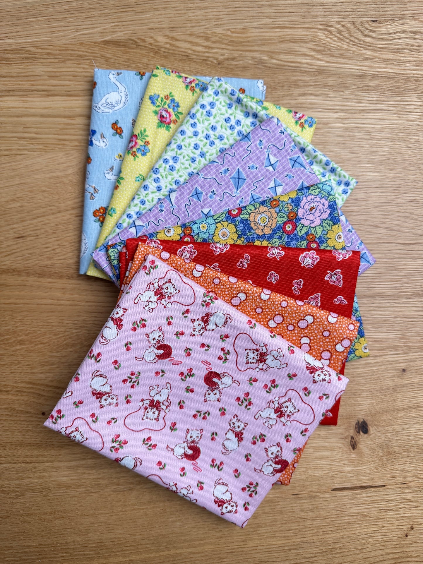 Traditional 30's fat quarters in blue, pink, red, purple, orange, and yellow prints by Lindsay Wilkes for Riley Blake Designs.