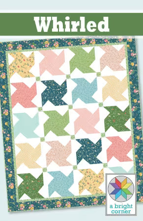 Colorful quilt with star patterns and 'Whirled' branding on a green banner.
