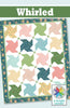 Colorful quilt with star patterns and 'Whirled' branding on a green banner.