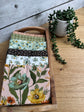 Stylized photo of 6 fat quarters from Worth Repeating fabric collection with the Blush main print .  